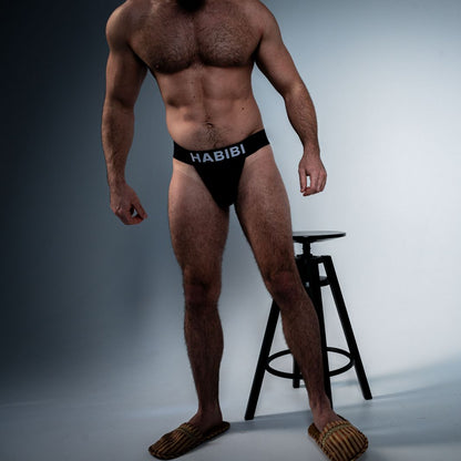 Full-body studio image of a model wearing the black 3EIB Habibi English jockstrap