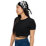 Model wearing a black bandana with bold white Arabic calligraphy as a tied headscarf