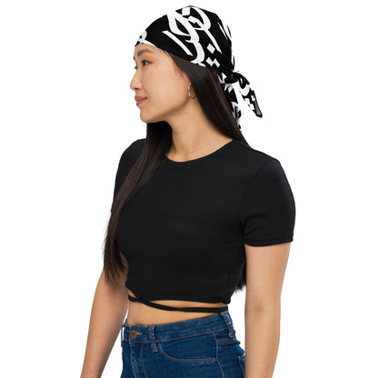 Model wearing a black bandana with bold white Arabic calligraphy as a tied headscarf