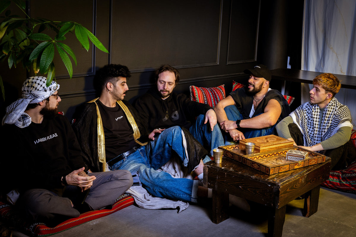 Habibi community members gathered in the majles, wearing Habibi clothing