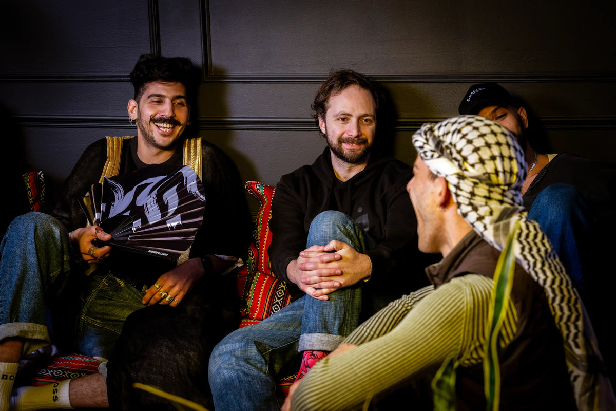 People sitting around the Majles table with an open fan
