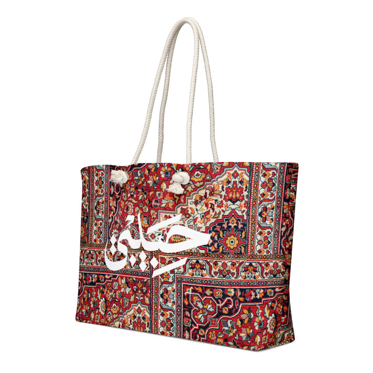 Red rug-print Habibi weekender bag with cream rope handles, left angled view