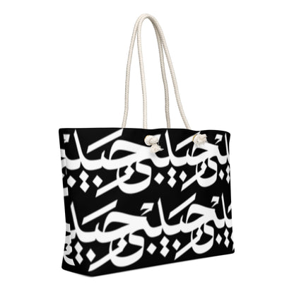Black-and-white Habibi calligraphy tote with cream rope handles, right angled view